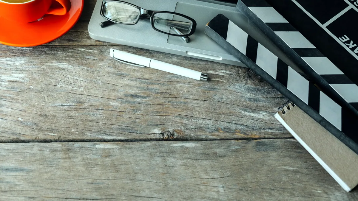A clapperboard resting on an editing table beside cut film.