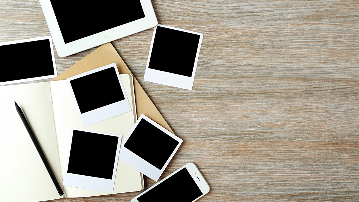 Scattered polaroid photographs spread across a dark table.